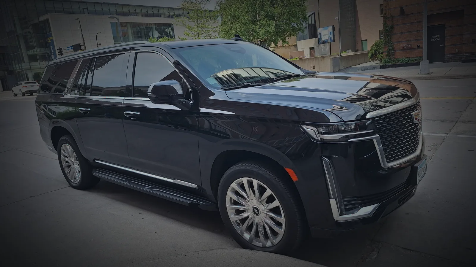 Front three-quarter view of a black Cadillac Escalade on a city street